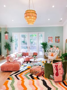 a living room filled with furniture and a chandelier hanging over the top of it