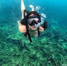 a woman swimming in the ocean wearing a mask