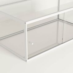 a white shelf with glass shelves on the top and bottom, against a white background