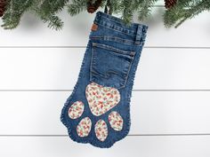 a christmas stocking hanging from the side of a tree with paw prints on it