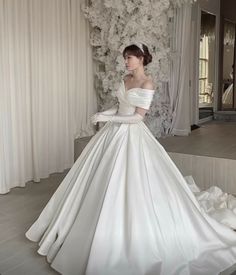 a woman in a white wedding dress standing on stairs