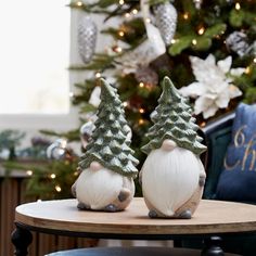 two small christmas trees sitting on top of a table