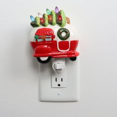 a red and white light switch cover with christmas decorations on it's face, hanging from the wall