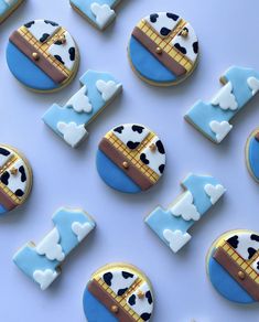 decorated cookies are arranged in the shape of boats and cows on blue background with white border