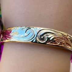 Everyone was asking for a Hawaiian Scroll Bangle that didn’t require a size, so we designed a new one just for you! This beautiful adjustable bangle is Gold Plated over Brass so it’s super affordable! Exquisite Hawaiian scrollwork adorns the whole bracelet as it adjusts from size 7.5 all the way up to size 9. The comfortable design tapers from 10mm to 5mm and is great for all ages! 14K gold plated over Brass Adjusts from size 7.5 to size 9 Tapered Design from 10mm to 5mm wide Hand engraved Hawai Adjustable Intricate Design Cuff Bracelet, Adjustable Engraved Bangle, Adjustable Round Etched Bracelets, Unique Adjustable Bracelets With Intricate Design, Adjustable Etched Round Bracelets, Adjustable Etched Bangle Bracelets, Adjustable Bracelets With Intricate Design, Adjustable Etched Bracelets, Intricate Design Adjustable Jewelry