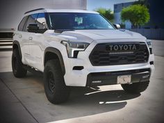 a white toyota truck parked in front of a building