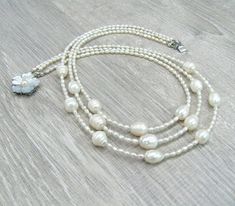 "Triple pearl necklace, layering multi strand necklaces, Mother's day gift, gift for bride, wedding pearl jewelry, white rice pearls, freshwater pearls. Length: 17.5\" or 44 cm by shorter strand. Please see photos on the model. Small rice shaped freshwater pearls measure 3X4 mm, they are white color with cream overtone, lustrous. You can see they are made by nature, because every bead has its own individuality, no 2 beads look alike. I used larger rice shaped freshwater pearl beads for the centr Pearl White Multi-strand Pearl Necklace, Multi-strand Pearl White Necklace With Pearl Pendant, White Multi-strand Beaded Necklace With Pearl Drop, White Multi-strand Pearl Necklace, Multi-strand Pearl Necklace With Pearl Charm, Multi-strand Pearl Drop Wedding Necklace, Multi-strand Pearl Drop Wedding Necklaces, White Double Strand Pearl Necklace For Anniversary, Wedding Multi-strand Pearl Drop Necklaces