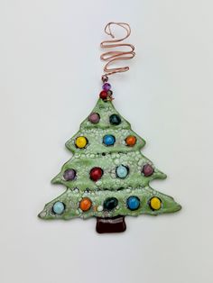 a ceramic christmas tree ornament hanging from a cord