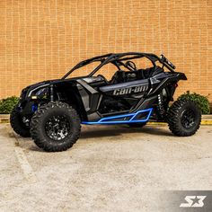 a black and blue can - am commander is parked in front of a brick wall