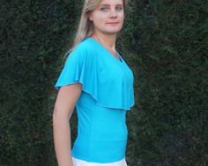 Extraordinary summer shirt with large asymmetric cape in turquoise & blue-Taidy - handmade Summer jersey blouse made of fine natural viscose jersey - handmade and hand-painted. With this blouse shirt, here in turquoise green, you have a real all-round treasure for your wardrobe. Whether for the office or on holiday, this blouse shirt is suitable for all occasions, it is practical and crease-resistant. The blouse shirt goes perfectly with jeans, but also with a skirt. The asymmetrical cape is a b Spring Fitted Turquoise Blouse, Fitted Turquoise Blouse For Spring, Fitted Turquoise Short Sleeve Tops, Turquoise Fitted Short Sleeve Top, Casual Stretch Turquoise Tops, Casual Turquoise Stretch Tops, Fitted Turquoise Casual Top, Fitted Turquoise Tops For Spring, Turquoise Short Sleeve Tops For Spring