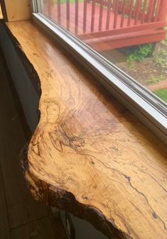 a wooden bench sitting next to a window