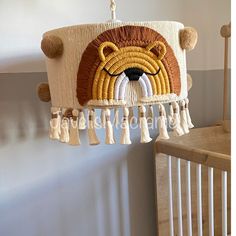 a bear lamp hanging from the side of a wall next to a baby crib