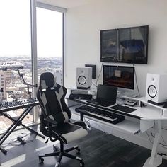 a desk with a computer, keyboard and speakers