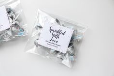 two bags filled with candies sitting on top of a white table next to each other