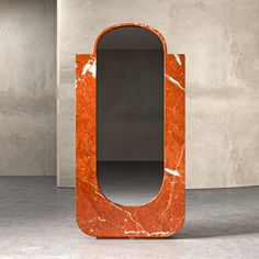 an orange and white marbled mirror sitting on top of a floor next to a wall