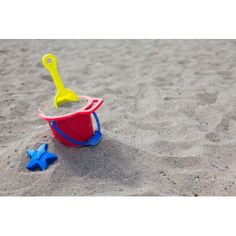 a toy sand pail and shovel in the sand