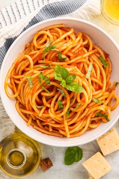 a white bowl filled with spaghetti and basil