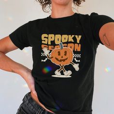 Grab your cute spooky Pumpkin babytee!  Perfect gift for Halloween lovers 🎃. ++ PLEASE READ++ 🤍 ABOUT THE Y2K BABY TEE: * Made with 100%, (5.3 oz/yd² (180 g/m heavy cotton. * This is a made-to-order T-shirt. * The shirt is Gildan 5000B. * Made using ethically grown and harvested cotton.  📏 SIZES: This is a CHILD'S T-shirt so please check the measurements table in the pictures to ensure a perfect fit.  ❗ It is not a crop top. Tip:  If unsure, grab your favorite baby tee, measure it while it's Cute Halloween T-shirt With Screen Print, Spooky Halloween T-shirt With Cartoon Print, Cute Halloween Graphic Print T-shirt, Halloween Lovers, Y2k Baby Tee, Spooky Pumpkin, Baby T Shirts, Baby T Shirt, Spooky Halloween