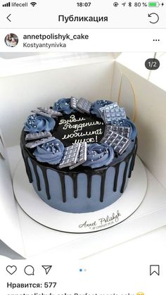 a birthday cake is decorated with blue and black icing