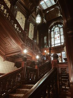 an ornate wooden staircase with stained glass windows