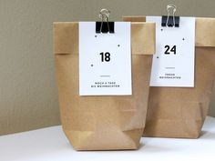 two brown paper bags with numbered tags on them