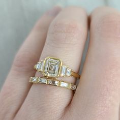 1.11ct M/SI2 GIA certified emerald cut diamond with 0.22ctw baguette cut accent diamonds bezel set in a handcrafted 18K yellow gold mounting. Gold Radiant Cut Diamond Ring With Baguette Diamonds, Gold Radiant Cut Diamond Ring With Baguettes, Gold Asscher Cut Diamond Ring With Baguette Diamonds, Gold Emerald Cut Diamond Ring With Single Cut Diamonds, Asscher Cut Gold Diamond Ring With Baguette Diamonds, Heirloom Emerald Cut Baguette Diamond Jewelry, Heirloom Baguette Diamond Emerald Cut Jewelry, Emerald Cut Moissanite Ring With Baguette Diamonds, Gold Baguette Cut Lab Grown Diamond Ring