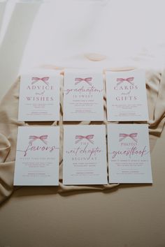 six cards with pink bows on them sitting on a bed