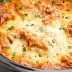 a casserole dish with meat and cheese on top, garnished with parsley