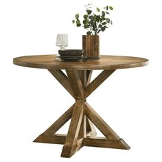 a round wooden table with two vases on it and some flowers in the middle