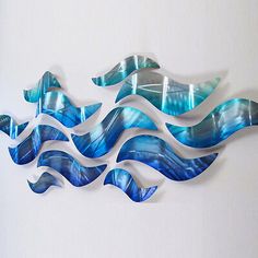 a blue and white wall sculpture with waves on it