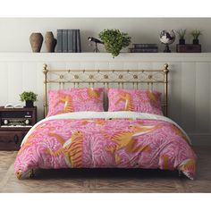 a bed with pink and yellow bedspread in a room