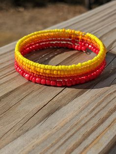 three different colored bracelets sitting on top of a wooden table