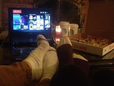 a person sitting in front of a laptop computer with their feet up on the table