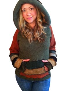 a woman wearing a hat and sweater with her hands in her pockets while posing for the camera