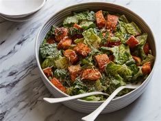 a bowl filled with lettuce and cubed meat