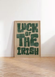 a poster with the words luck of the irish on it in front of a white wall