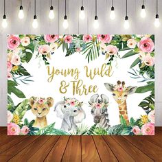 a baby shower sign with pink flowers and giraffes on it, surrounded by greenery