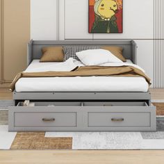 a bed with two drawers underneath it in a room that has beige walls and wood flooring