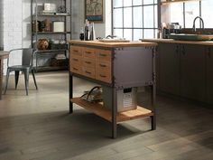 an industrial style kitchen with wood flooring and stainless steel appliances in the center island