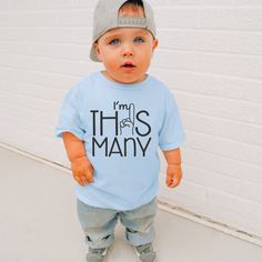 "Get ready to celebrate that special milestone with our \"I'm This Many\" boys t-shirt!  Featuring a playful design with a hand holding up a finger to represent the number 1, its perfect for your little one's first birthday or cake smash outfit.  Made from soft fabric, it's not just adorable but also practical for all day wear.   Let your little guy shine in style on his big day with this adorable t-shirt! These t-shirts are mostly Gildan, Bella, or Rabbit Skins." Cute T-shirt For First Birthday And Father's Day, Cute T-shirt For First Birthday On Father's Day, Funny First Birthday T-shirt With Letter Print, Fun Blue Top For First Birthday, Funny Letter Print T-shirt For First Birthday, Baby Boys First Birthday, Boys First Birthday, 1st Birthday Shirt, First Birthday Shirt