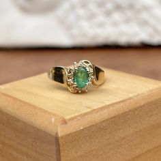 Estate/ vintage 14KT yellow gold concave band ring with oval, genuine emerald + diamond accents in a halo setting. Nicely saturated, medium green emerald in a vintage concave style band. Size 6.25 Weight: 3.00 grams Genuine, oval-cut emerald measures: 5mm x 4mm .65 carat Emerald Halo of round, natural diamonds= .12 CTW I'1 clarity; G color diamonds Stamped 14K Excellent estate condition Heirloom Oval Green Emerald Ring, Vintage Oval Emerald Ring With Diamond, Heirloom Oval Emerald Cluster Ring, Heirloom Oval Emerald Ring As May Birthstone, Vintage Green Diamond Ring With Halo Setting, Green Vintage Diamond Ring With Halo Setting, Green Diamond Ring With Halo Setting In Vintage Style, Vintage Emerald Ring With Halo Setting For May Birthstone, Vintage Green Cluster Ring With Halo Setting