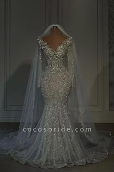 the back of a wedding dress with long sleeves and sequins on the shoulders