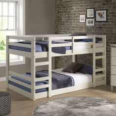 a white bunk bed with two sets of blue pillows on the top and bottom bunk