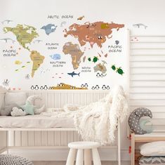 a child's bedroom with white walls and colorful world map decals on the wall