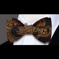 Unveiling Opulence: The Black and Gold Paisley Pattern Silk Bow Tie In the realm of sophisticated menswear, there exists an accessory that stands out as the epitome of refined elegance – the Black and Gold Paisley Pattern Silk Bow Tie. Imbued with a timeless paisley motif, this bow tie isn't just an accessory; it's a symbol of opulence and style that transcends fashion trends. Design Extravaganza: Black and Gold Paisley Pattern Prepare to be captivated by the intricate paisley pattern adorning t Classic Gold Bow Tie For Business, Gold Bow Tie For Business, Gold Classic Bow Tie For Business, Dapper Gold Bow Tie For Formal Occasions, Gold Dapper Bow Tie For Formal Occasions, Luxury Fitted Bow Tie For Formal Events, Elegant Gold Ties For Party, Gold Bow Tie For Formal Occasions, Elegant Gold Tie For Black-tie Events