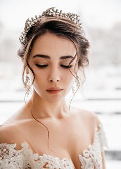 a woman wearing a tiara with pearls on it's head and her eyes closed