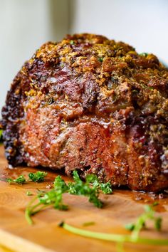 a large piece of meat sitting on top of a wooden cutting board next to parsley