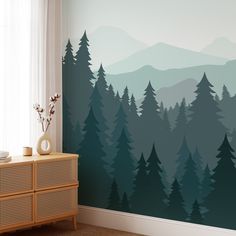 there is a wall mural in the room with trees on it and mountains behind it