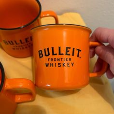 two orange coffee mugs sitting next to each other