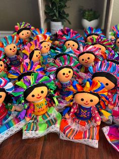 a group of colorful dolls sitting on top of a wooden floor next to each other